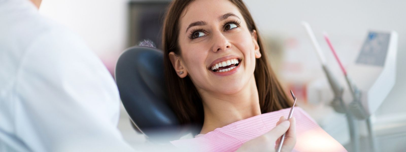 Beautiful girl with Brown hair looking at the Dentist smiling